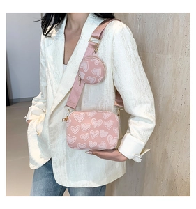 Fashionable pink heart pattern crossbody bag with round pouch on a model outfit