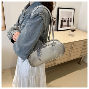Silver PU leather oval crossbody bag with a blue checkered bow pendant on model