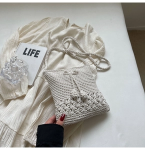 Detailansicht der cremefarbenen Häkeltasche mit floralem Lochmuster und praktischem Kordelzug