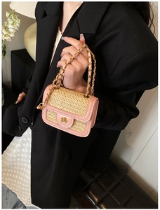 Dettaglio borsa a tracolla in pelle PU rosa e paglia intrecciata con chiusura a camelia