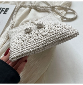 Nahaufnahme einer weißen Häkelumhängetasche mit filigranen floralen Strickmustern
