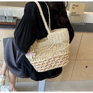 Détail du sac cabas en paille tissée avec motif en maille et breloque fleurie violette