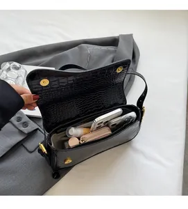Detail of black crocodile texture bag interior showing space for phone and wallet
