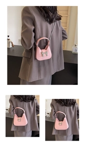 Detail of pink crescent bag with silver bow accent and detachable metal chain strap
