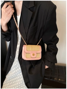 Dettaglio mini borsa in paglia con finiture in pelle rosa e chiusura a fiore dorato