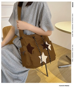 Brown canvas crossbody bag with star patchwork and textured drawstring detail