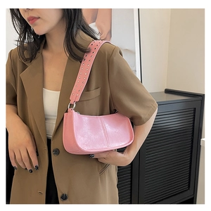 Chic pink glossy shoulder bag with silver rivet studs on wide strap shown on model