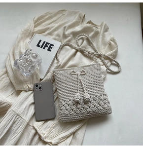 Detail der handgewebten beige Häkeltasche mit Blumenmuster und Kordelzug-Dekoration