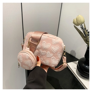 Pink heart-embossed crossbody bag with small round coin purse and adjustable wide strap