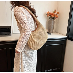 Fashionable straw shoulder bag shown with a stylish dress for a casual vacation look
