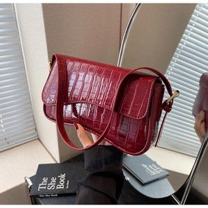 Close-up of wine red crocodile pattern shoulder bag with golden metal buckle and PU texture