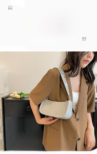 Detailed view of a silver minimalist hobo bag with eyelet strap on a model