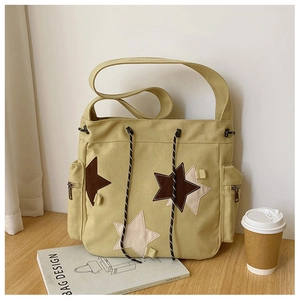 Detail of canvas shoulder bag showing star patches and drawstring closure texture