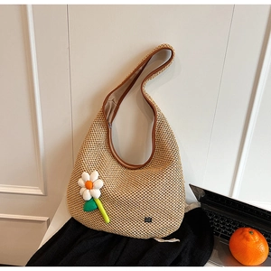 Fashionable straw shoulder hobo bag with brown leather trim and floral charm accessory