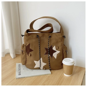 Detail of vintage brown canvas messenger bag with star patches and drawstring closure