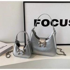 Detail of silver crescent bags set featuring metallic finish and bow buckle accents