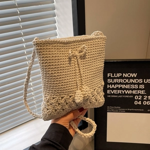 Minimalistische cremefarbene Häkeltasche mit hohlem Blumenmuster und gedrehtem Trageriemen