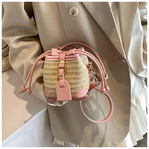Detail of pink leather and woven straw texture on a mini drawstring bucket bag