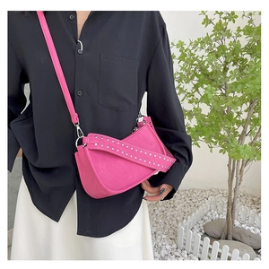 Detail of pink crossbody bag strap featuring double-row silver metal rivet decorations