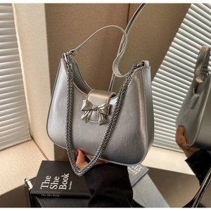 Detail shot of silver metallic hobo bag with chrome bow ornament and chain strap