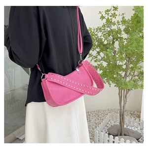 Detail of pink PU leather crossbody bag with silver studs and metal zipper on shoulder strap