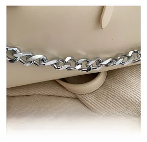 Nahaufnahme der cremefarbenen PU-Tasche mit strukturierter Oberfläche und silberner Kette