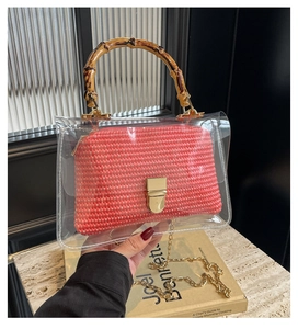 Detail of transparent PVC crossbody bag with bamboo handle and pink straw inner pouch