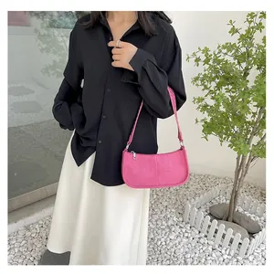 Fuchsia fuchsia rivet shoulder bag worn by model over a black and white outfit