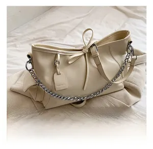 Detail der cremeweißen PU-Leder-Einkaufstasche mit Metallkette und dekorativer Schleife