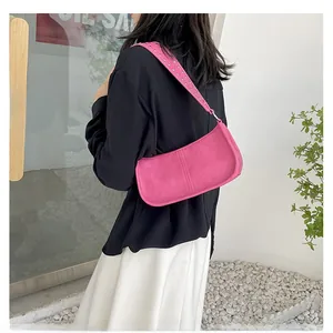 Fashionable rose pink shoulder bag with silver rivet studs on the strap shown on model