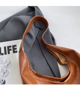 Detail of comfortable shoulder strap and soft brown leather texture on hobo tote bag