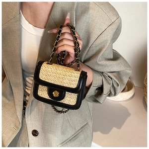 Dettaglio della trama in paglia e della chiusura a fiore dorato su una piccola borsa chic