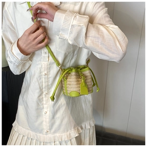 Straw mini bucket bag in lime green and beige leather shown on a white shirt model