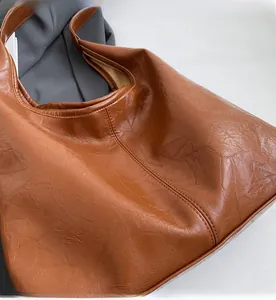 Close-up of brown faux leather hobo bag showing soft texture and stitching detail