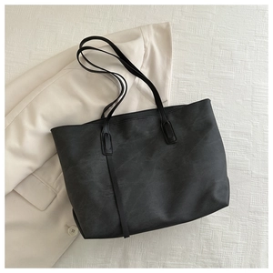 Borsa tote minimalista in pelle PU nera su sfondo bianco per l'abbigliamento da ufficio