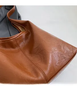 Detail of soft brown leather tote bag with vintage texture and fine stitching detail