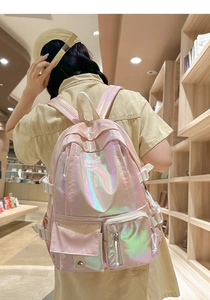 Girl wearing laser pink holographic backpack in a cozy bookstore setting with side view