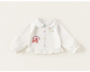 Détail du chemisier blanc pour fille avec pois colorés, ourlet à volants et broderie chat