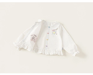 Détail d'une chemise blanche à pois pour fille avec col Claudine et boutons colorés