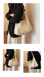Detail view of the cream white high-shine large tote bag featuring soft pleated texture