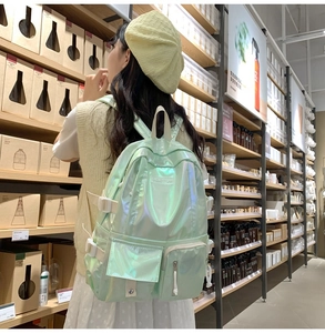 Detail view of laser PU backpack in holographic green with buckle and front flap pocket