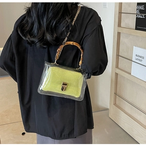 Detailed view of fashion transparent PVC bag with bamboo handle and green woven pouch