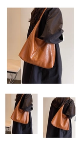 Detail shot of a dark brown oversized hobo bag showing wrinkled faux leather texture