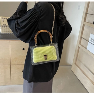 Detail of transparent PVC tote with neon yellow knit inner pouch and bamboo handle