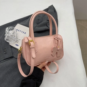 Pink PU leather cylinder handbag with double handles and decorative bow charm