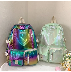 Detail of laser holographic PU leather backpacks showing vibrant metallic gradients and pockets