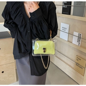 Close-up of stylish 2-in-1 transparent PVC handbag with lime green knit interior and bamboo handle