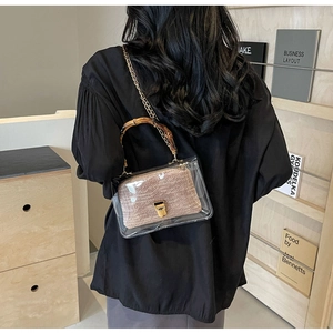 Detail of transparent PVC crossbody bag with woven inner pouch and bamboo handle