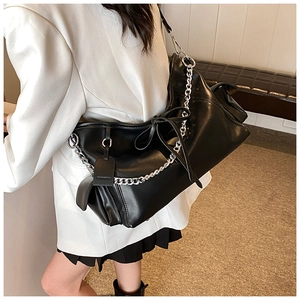 Details einer schwarzen PU-Ledertasche mit silberner Kette und Schleifenapplikation