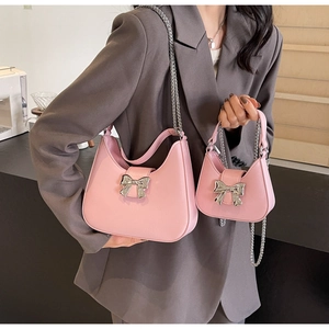 Detail of pink crossbody bag with silver bow buckle and matching mini coin purse set